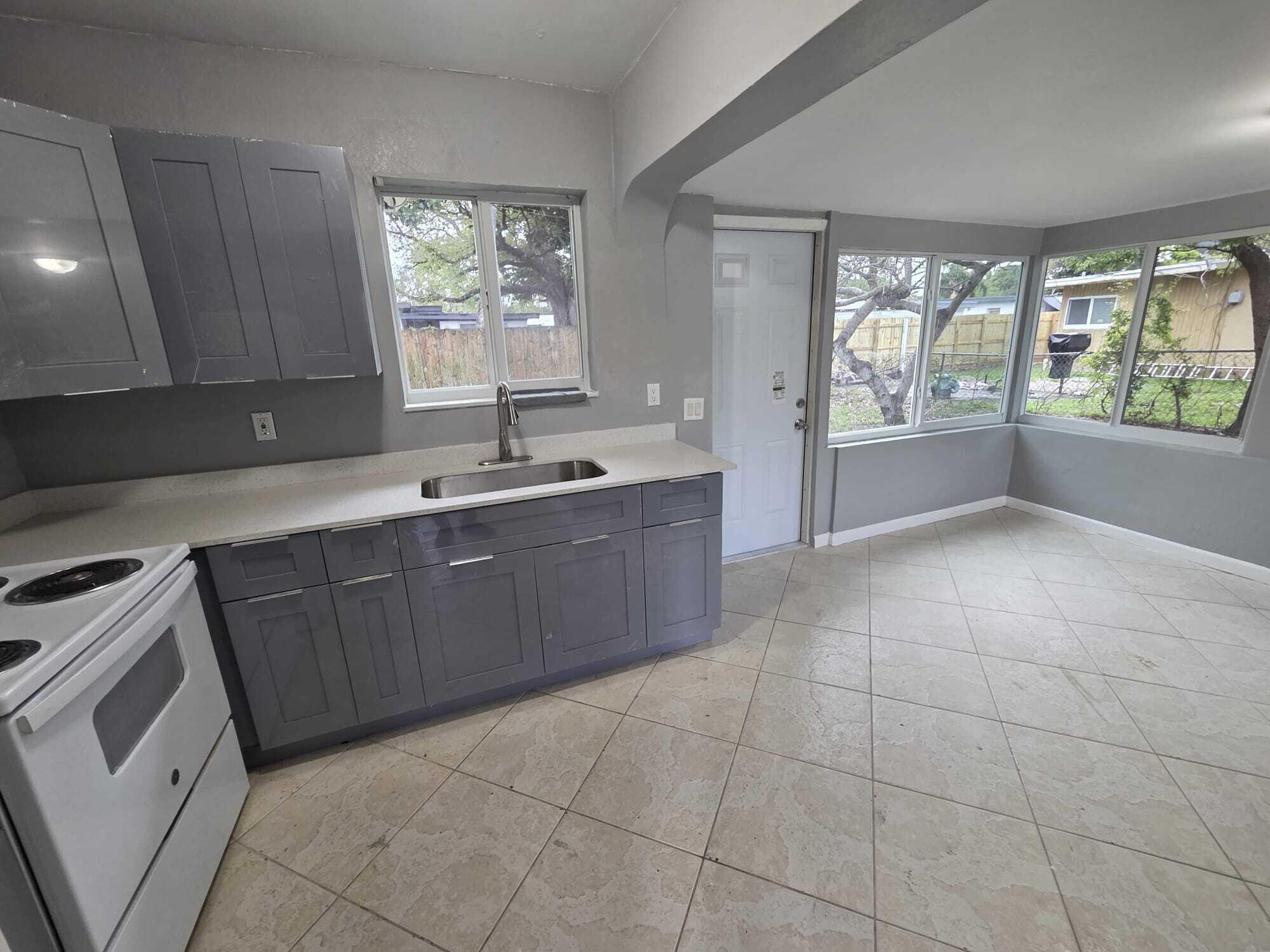 5720 Cleveland Street Hollywood, FL 33021 - Photo 2 of 18 a kitchen with a sink a counter top space and appliances