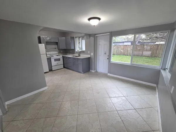 a large white kitchen with a large window