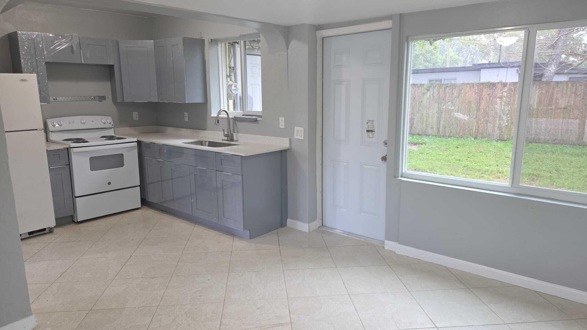 5720 Cleveland Street Hollywood, FL 33021 - Photo 4 of 18 a kitchen with a stove a sink and a window