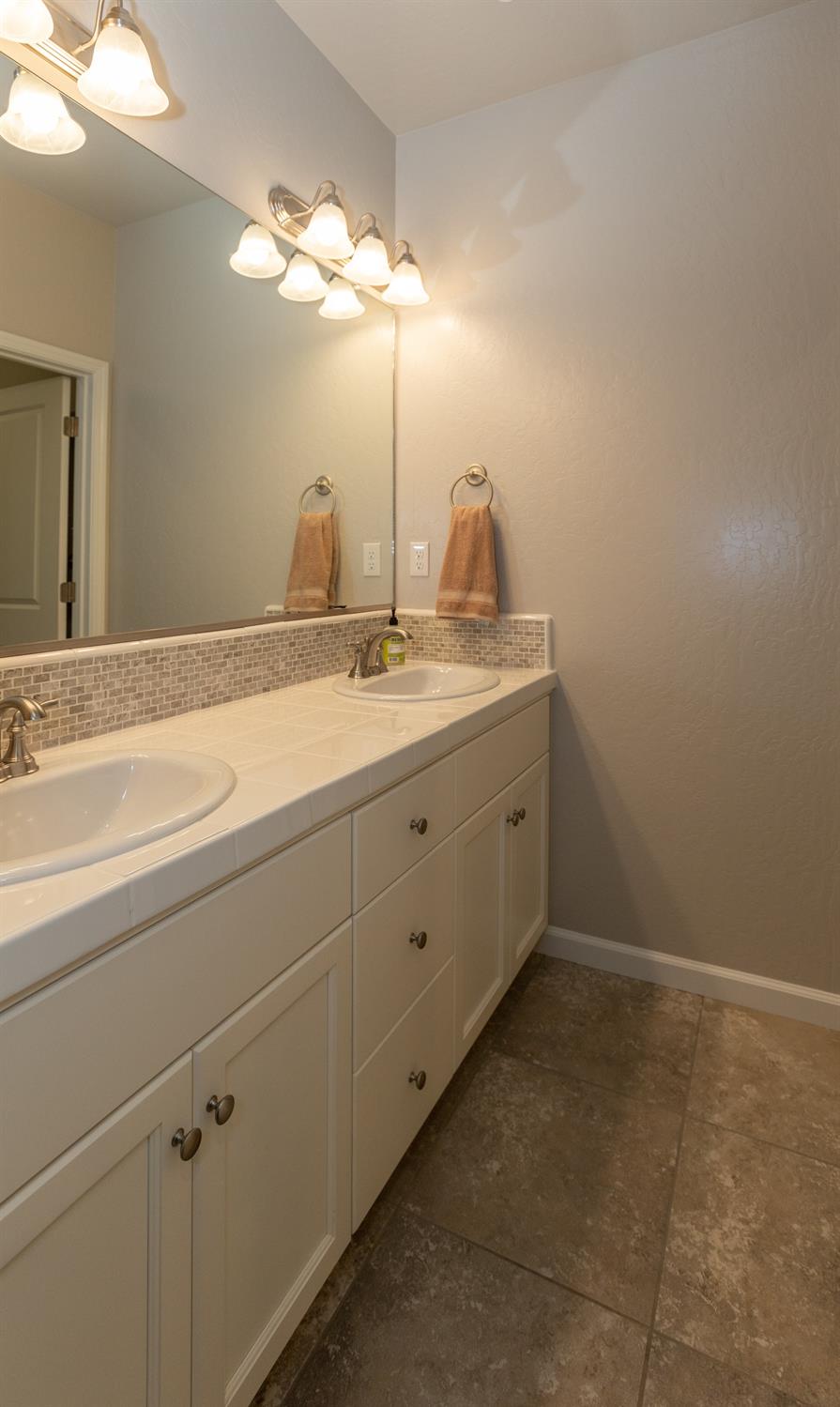 1063 Soledad Avenue Clovis, CA 93619 - Photo 16 of 26 a bathroom with a double vanity sink and mirror