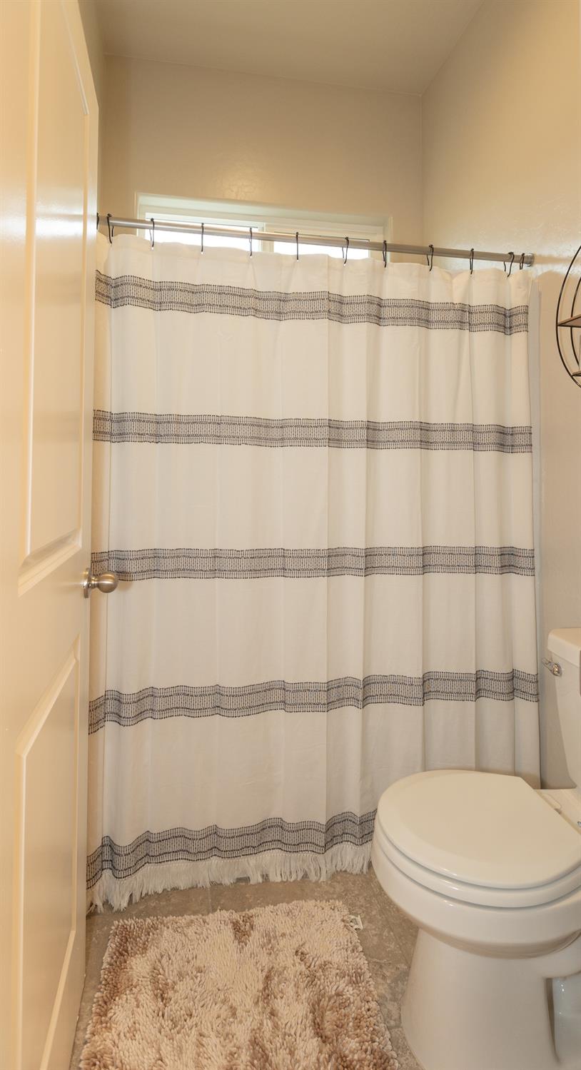 1063 Soledad Avenue Clovis, CA 93619 - Photo 17 of 26 a bathroom with a toilet and a shower