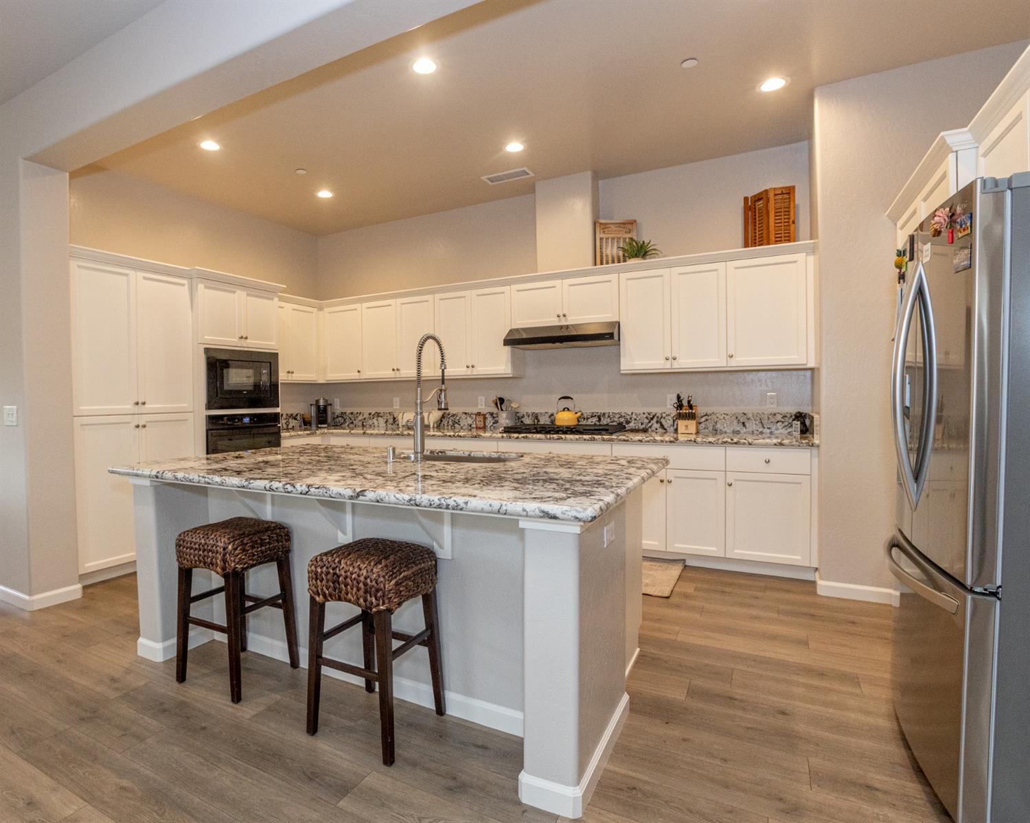 1063 Soledad Avenue Clovis, CA 93619 - Photo 6 of 26 a kitchen with kitchen island granite countertop wooden cabinets and refrigerator
