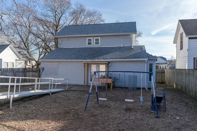 a view of a house with a backyard and chairs
