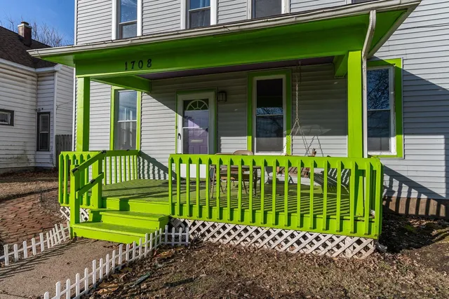 a green field with yellow house in front of it