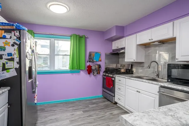 a kitchen with kitchen island a sink wooden floor and a window