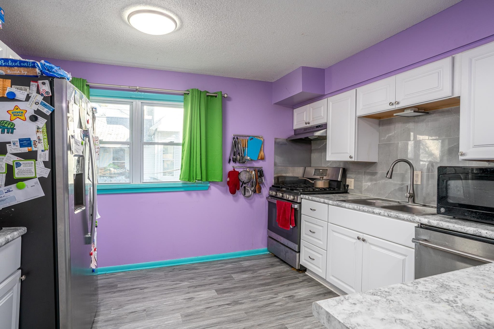 1708 Pershing Boulevard Clinton, IA 52732 - Photo 5 of 18 a kitchen with kitchen island a sink wooden floor and a window