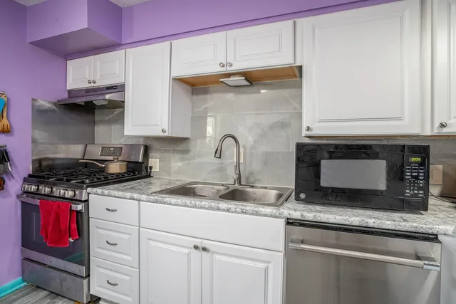 a kitchen with granite countertop a stove and a sink