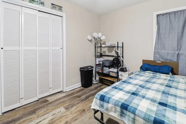 a bedroom with a bed and wooden floor