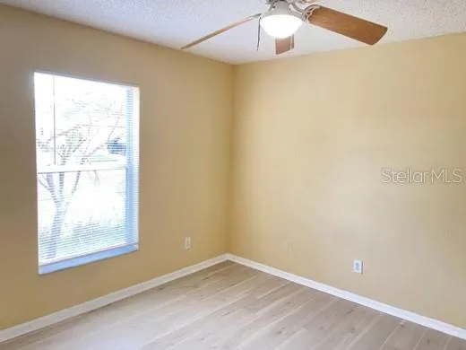 an empty room with a window and wooden floor