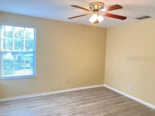 an empty room with a window and a fan
