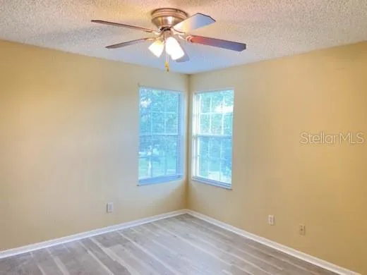 an empty room with a window and a fan