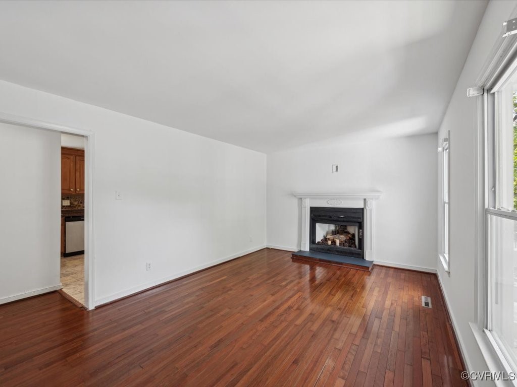 1407 Oldbury Road Midlothian, VA 23113 - Photo 6 of 34 an empty room with wooden floor fireplace and windows