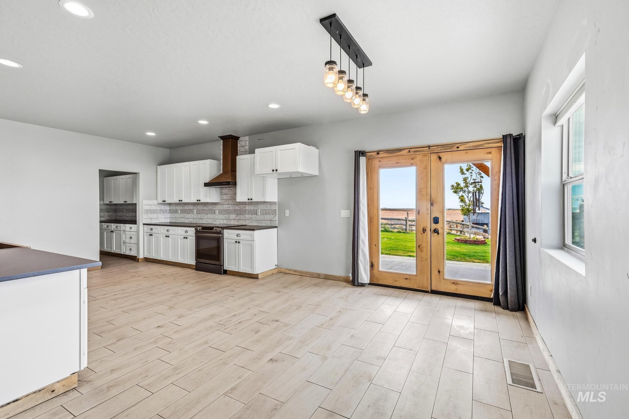 870 Desert Wind Road Boise, ID 83716 - Photo 8 of 50 Kitchen featuring white cabinetry with dark hardware, dark countertops, and a subway tile backsplash