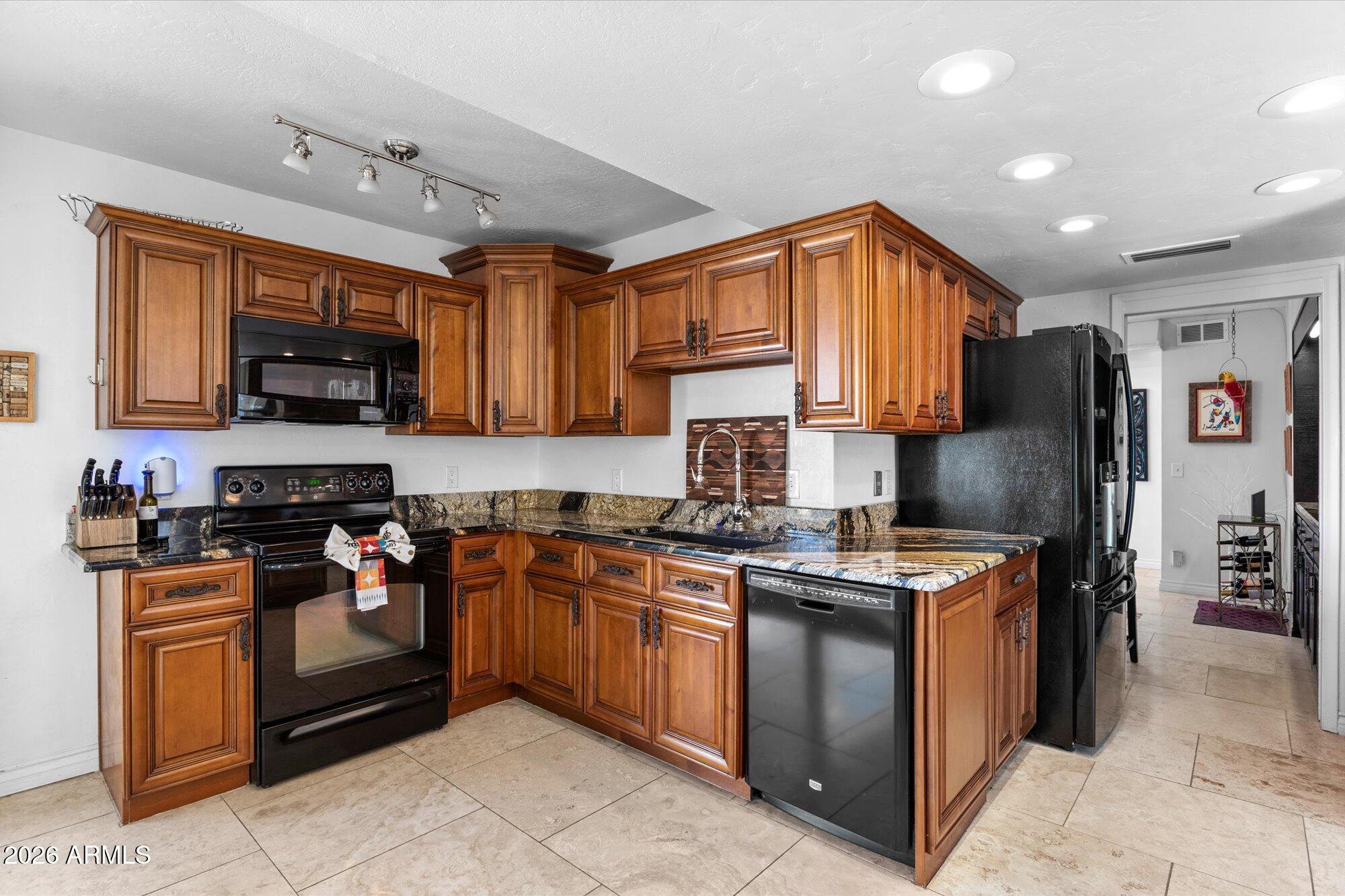 7005 North Barbados Place Phoenix, AZ 85021 - Photo 16 of 42 a kitchen with stainless steel appliances granite countertop a stove top oven a sink dishwasher a refrigerator and a microwave