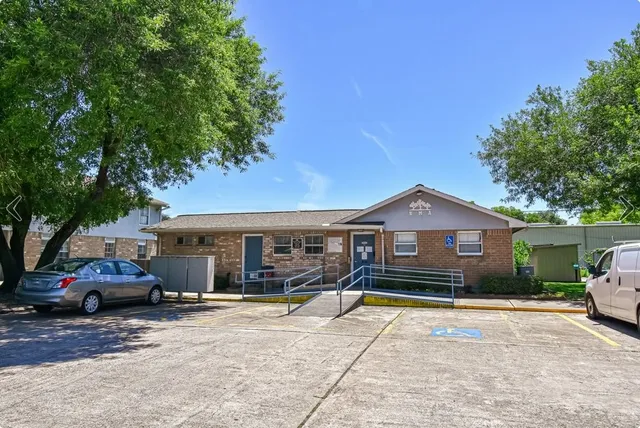 a front view of a house with a garden and parking