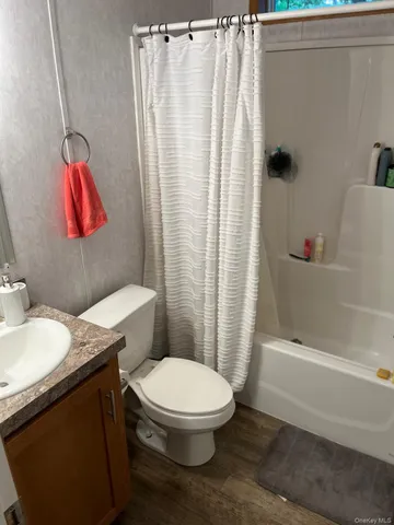 a bathroom with a granite countertop bathtub sink vanity mirror and toilet