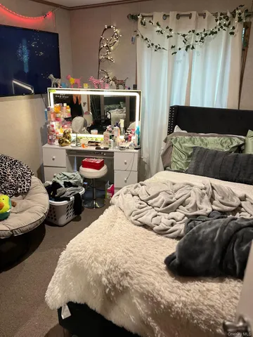 a bedroom with a bed a couch and a view of kitchen