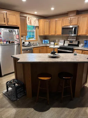 a kitchen with stainless steel appliances a stove a sink a microwave a refrigerator and cabinets