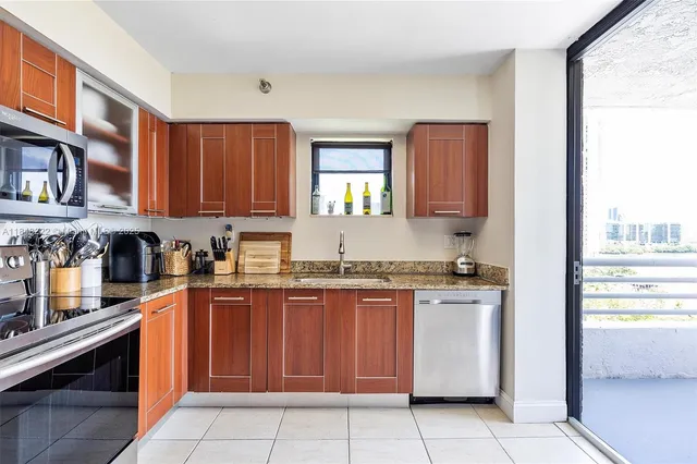 a kitchen with granite countertop a refrigerator and a sink