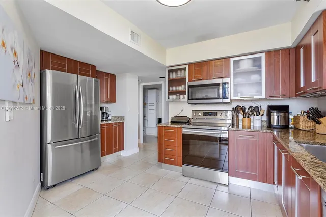 a kitchen with stainless steel appliances granite countertop a refrigerator and a stove top oven