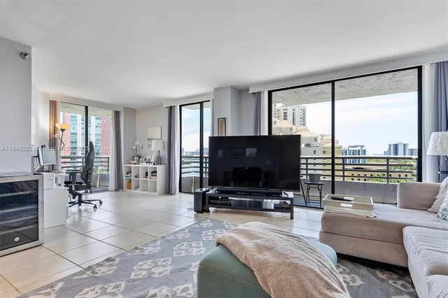 a living room with furniture a flat screen tv and a large window