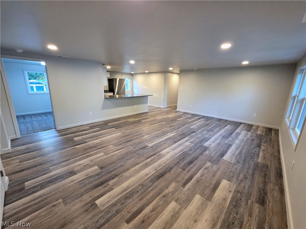 6145 Virginia Road Nashport, OH 43830 - Photo 2 of 24 Spacious room featuring wood-finish flooring, recessed lighting, neutral wall tones, and a breakfast bar