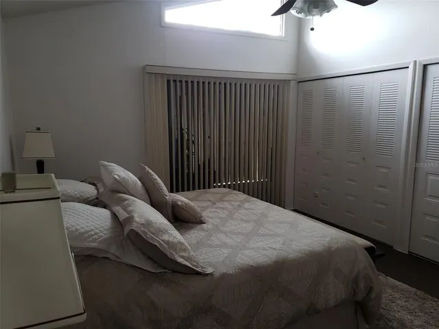 a bedroom with bed and with the fan