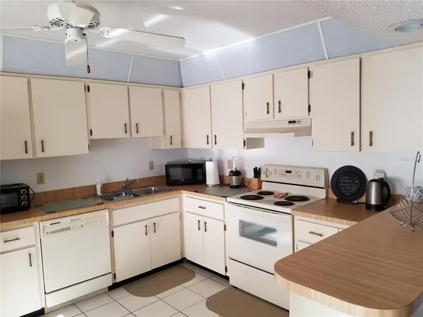 a kitchen with cabinets appliances a sink and a counter