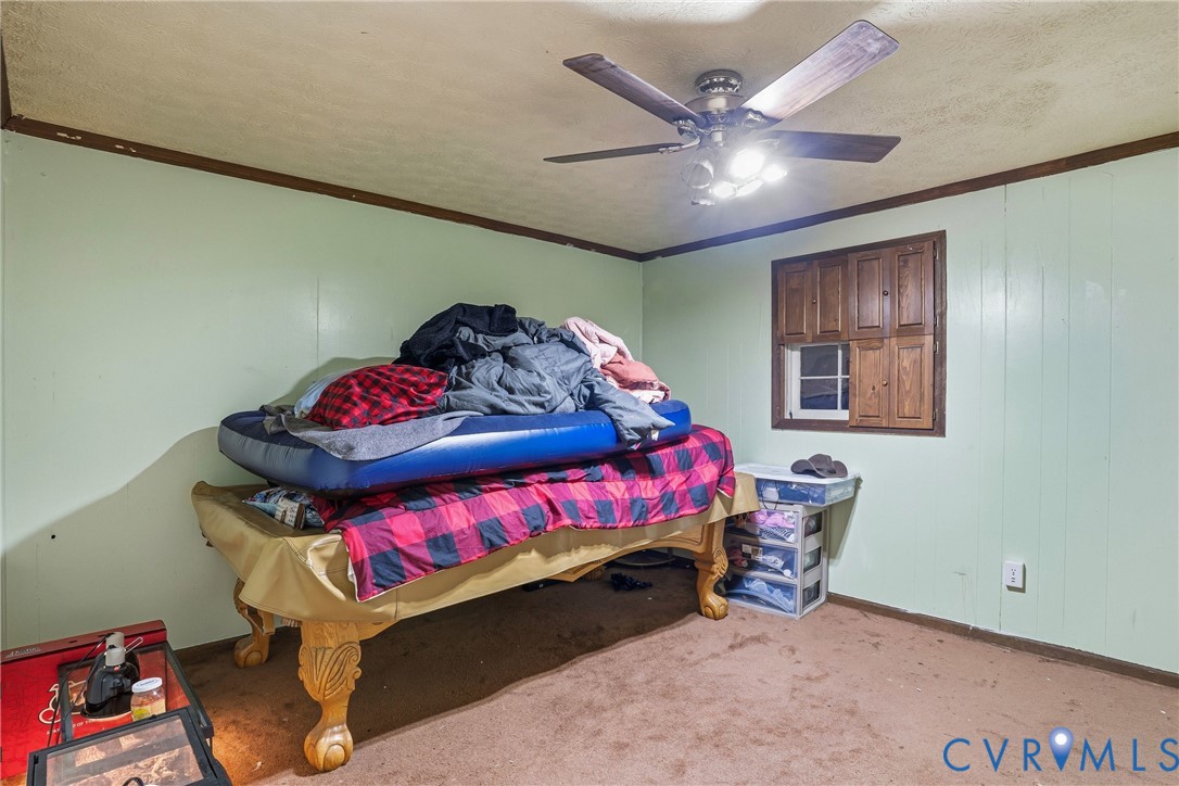 14219 Spruce Avenue Chester, VA 23836 - Photo 25 of 32 a bedroom with a bed and a chandelier