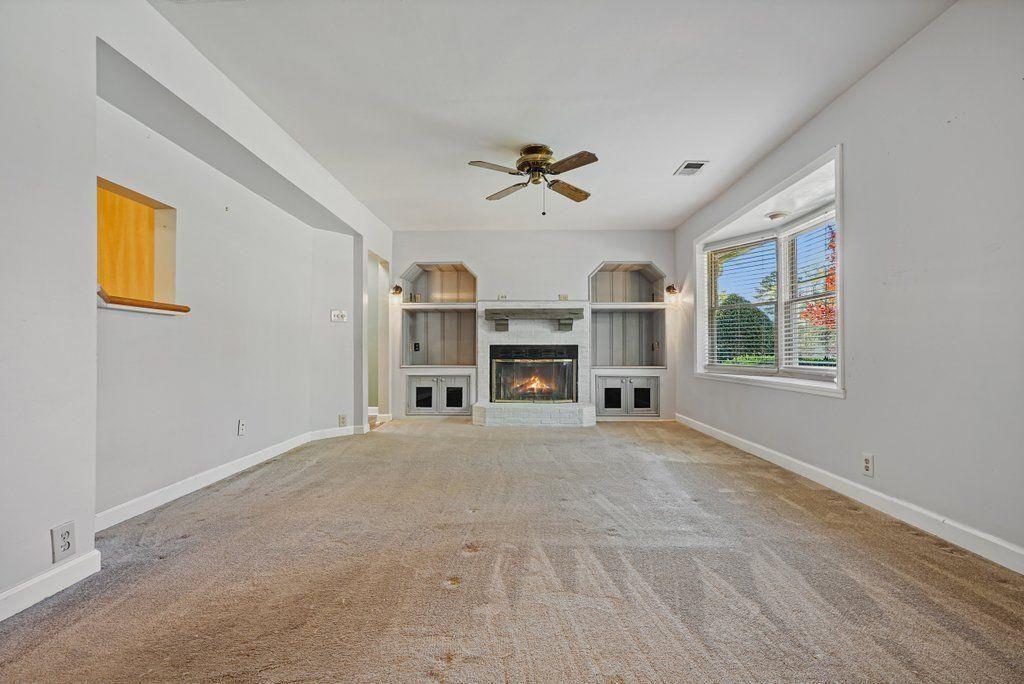 3799 Oglesby Road Powder Springs, GA 30127 - Photo 3 of 39 a view of a livingroom with a fireplace a ceiling fan and windows