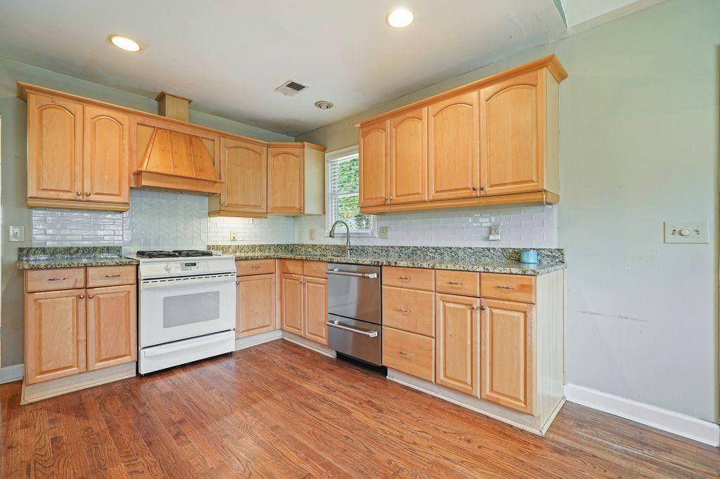 3799 Oglesby Road Powder Springs, GA 30127 - Photo 4 of 39 a kitchen with granite countertop wooden cabinets and white appliances