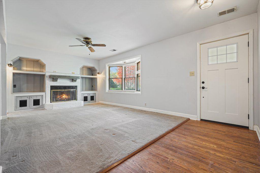 3799 Oglesby Road Powder Springs, GA 30127 - Photo 7 of 39 an empty room with fireplace cabinet and windows
