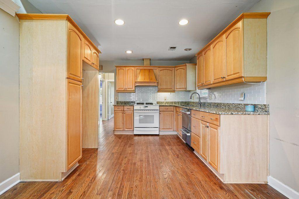 3799 Oglesby Road Powder Springs, GA 30127 - Photo 9 of 39 a kitchen with stainless steel appliances granite countertop a refrigerator a sink dishwasher a stove and white countertops with wooden floor