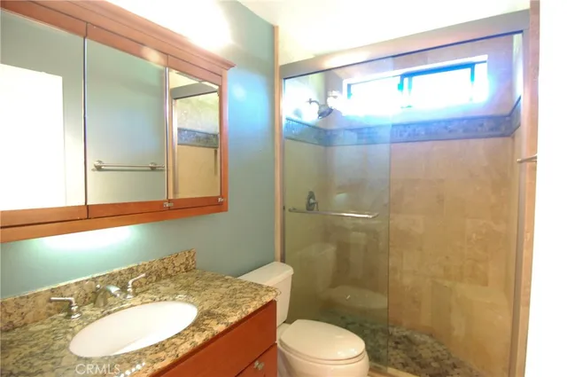 a bathroom with a sink a toilet and shower