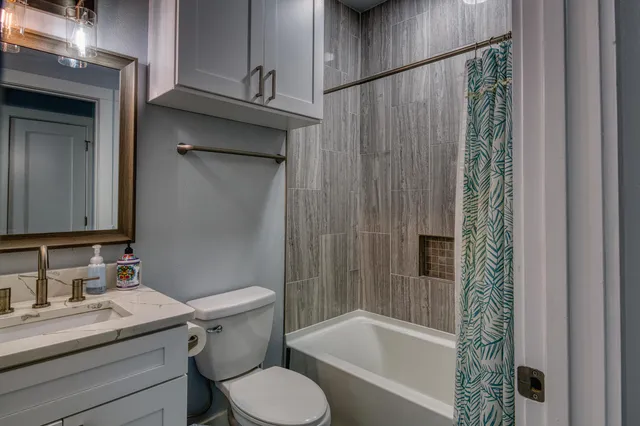 a bathroom with a granite countertop sink toilet and shower