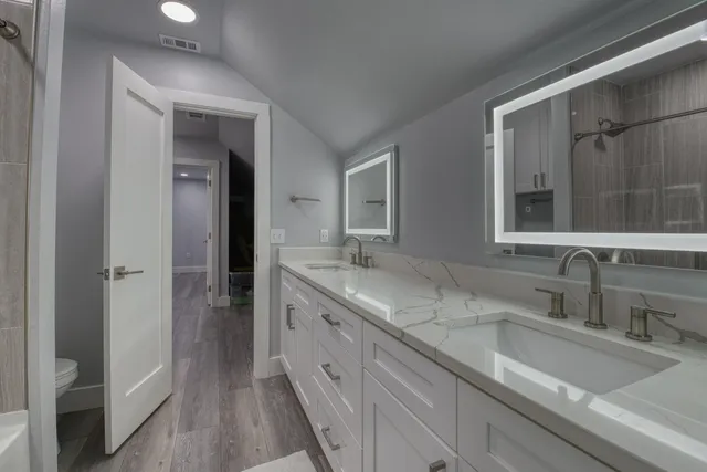 a spacious bathroom with a double vanity sink and a mirror