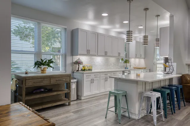 a kitchen with kitchen island a stove a center island a dining table and chairs