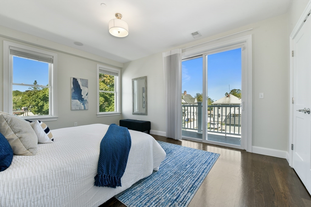 884 Adams Street, Unit 3 Boston, MA 02124 - Photo 11 of 24 a bedroom with a balcony a bed and a large window