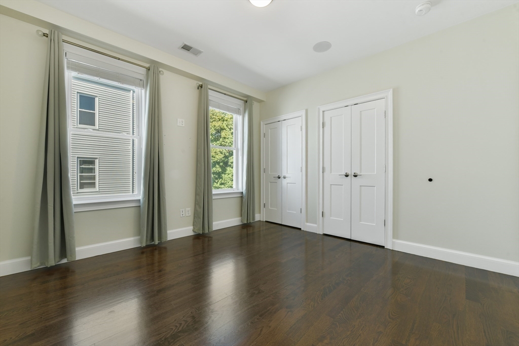 884 Adams Street, Unit 3 Boston, MA 02124 - Photo 16 of 24 a view of an empty room with wooden floor and a window