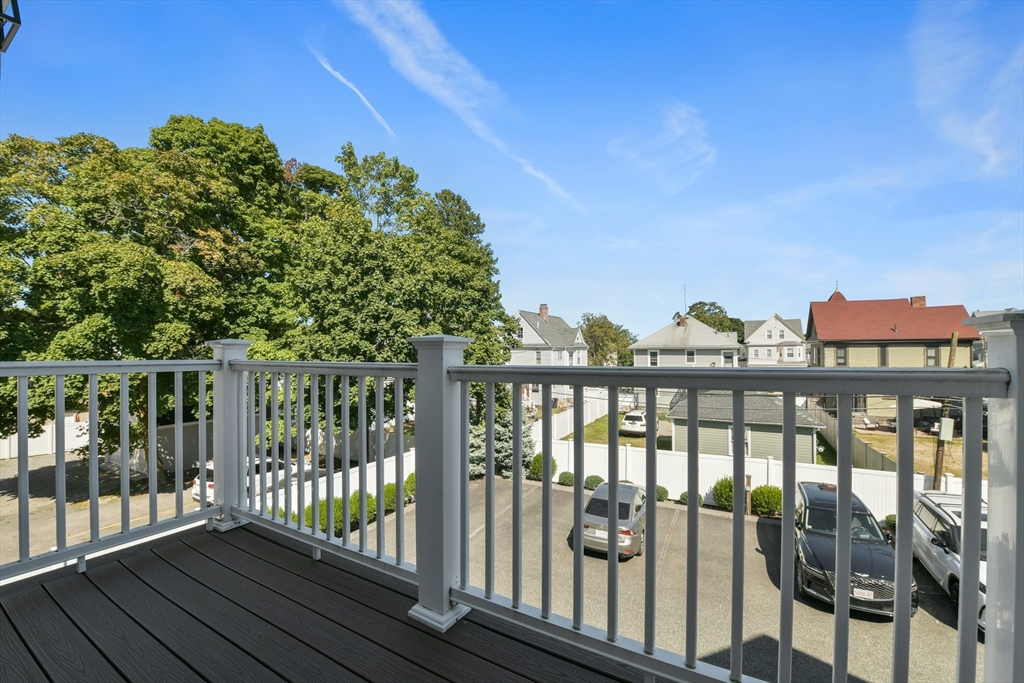 884 Adams Street, Unit 3 Boston, MA 02124 - Photo 22 of 24 a view of a balcony with a floor to ceiling window and wooden fence
