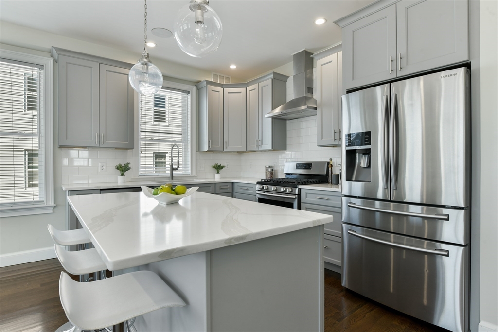 884 Adams Street, Unit 3 Boston, MA 02124 - Photo 3 of 24 a kitchen with stainless steel appliances a refrigerator sink and cabinets