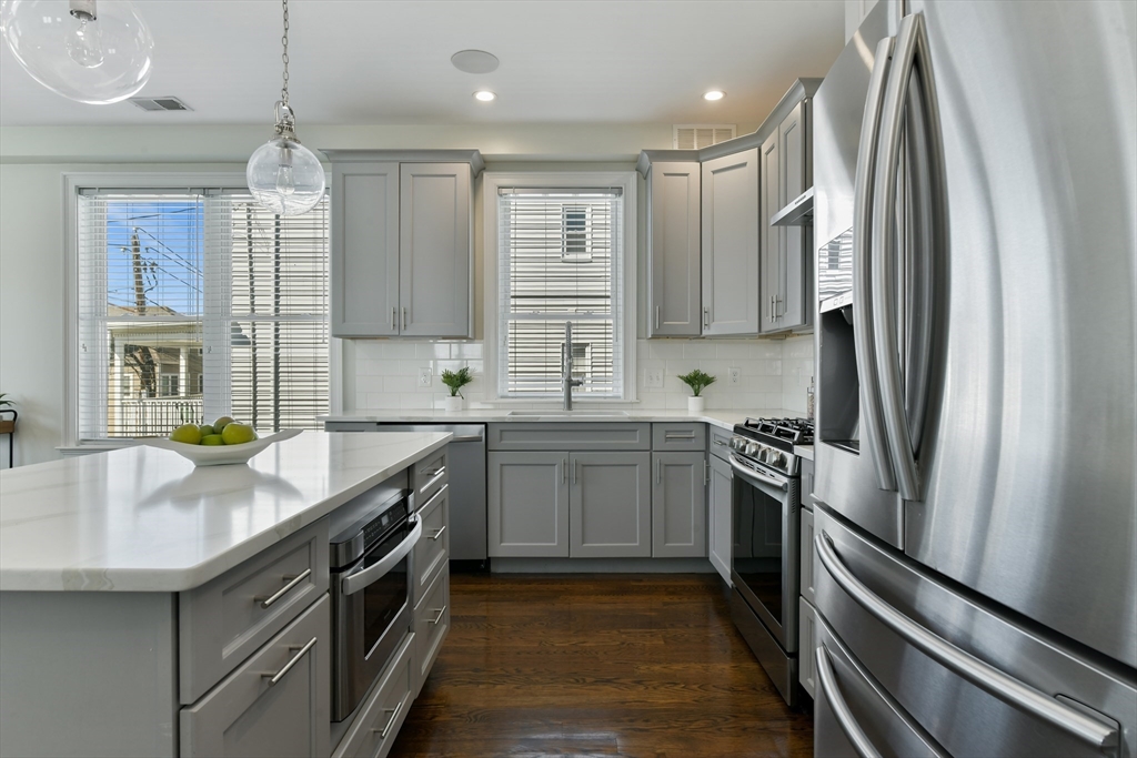884 Adams Street, Unit 3 Boston, MA 02124 - Photo 4 of 24 a kitchen with stainless steel appliances granite countertop a sink stove and refrigerator