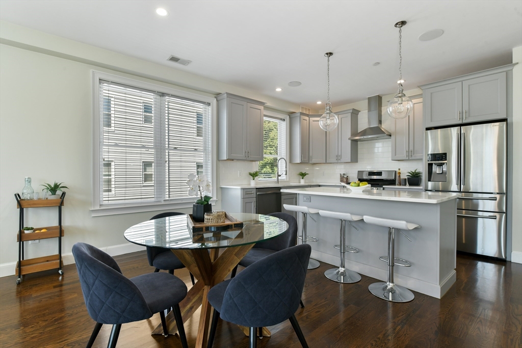 884 Adams Street, Unit 3 Boston, MA 02124 - Photo 7 of 24 a kitchen with a dining table chairs and refrigerator