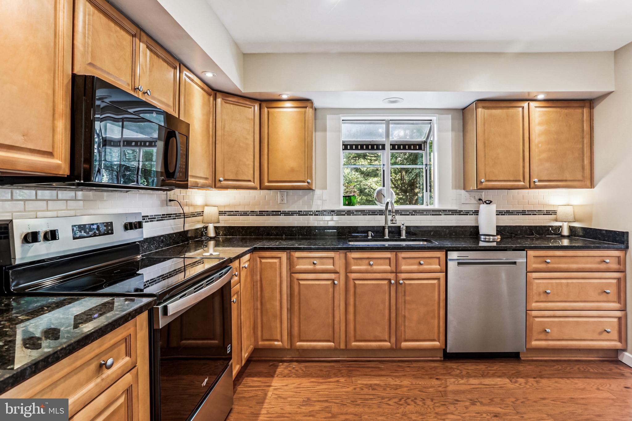 9013 2nd Avenue Silver Spring, MD 20910 - Photo 13 of 56 a kitchen with stainless steel appliances granite countertop a stove a sink and a microwave