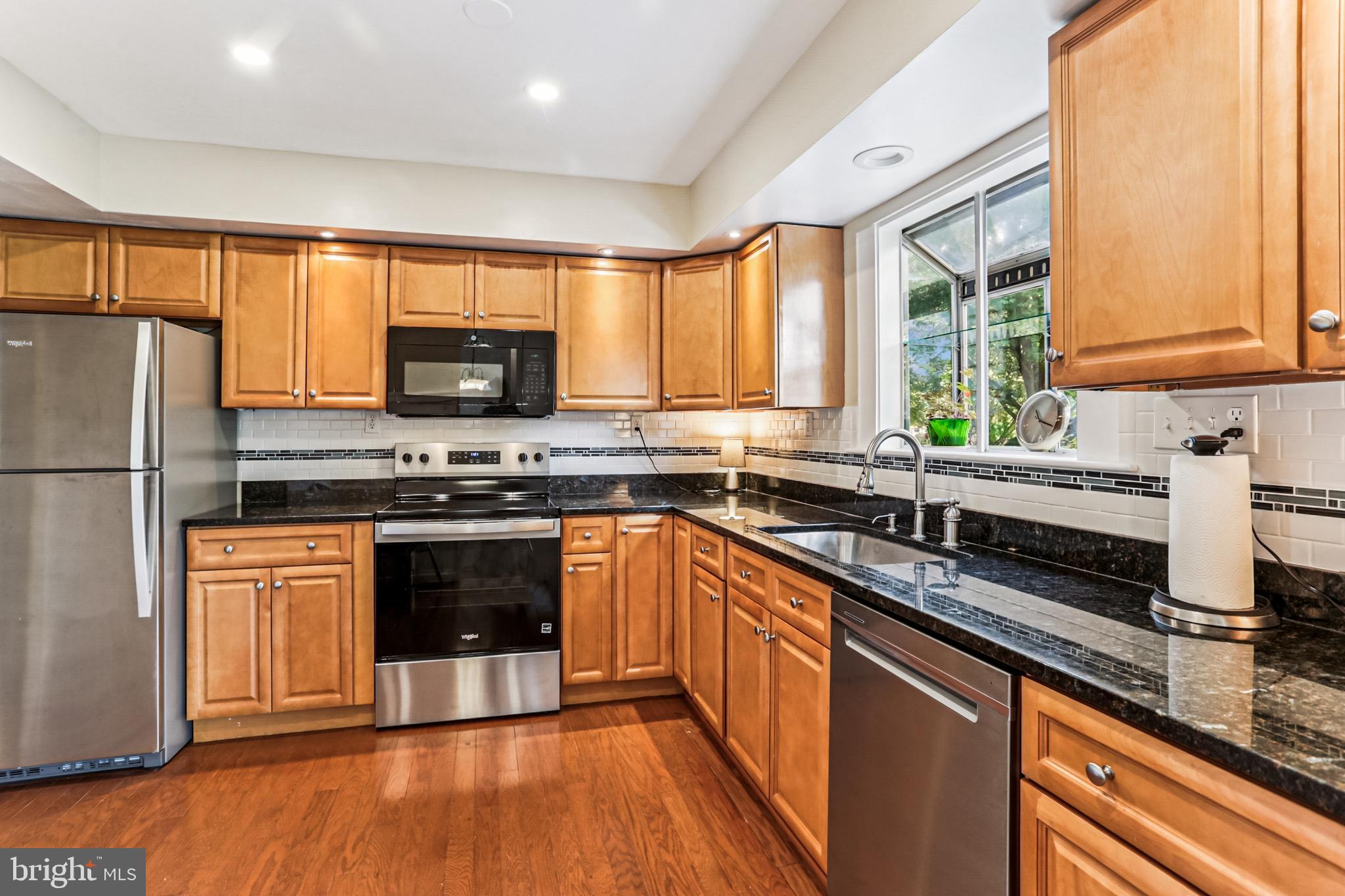 9013 2nd Avenue Silver Spring, MD 20910 - Photo 15 of 56 a kitchen with stainless steel appliances granite countertop a stove a sink and a refrigerator