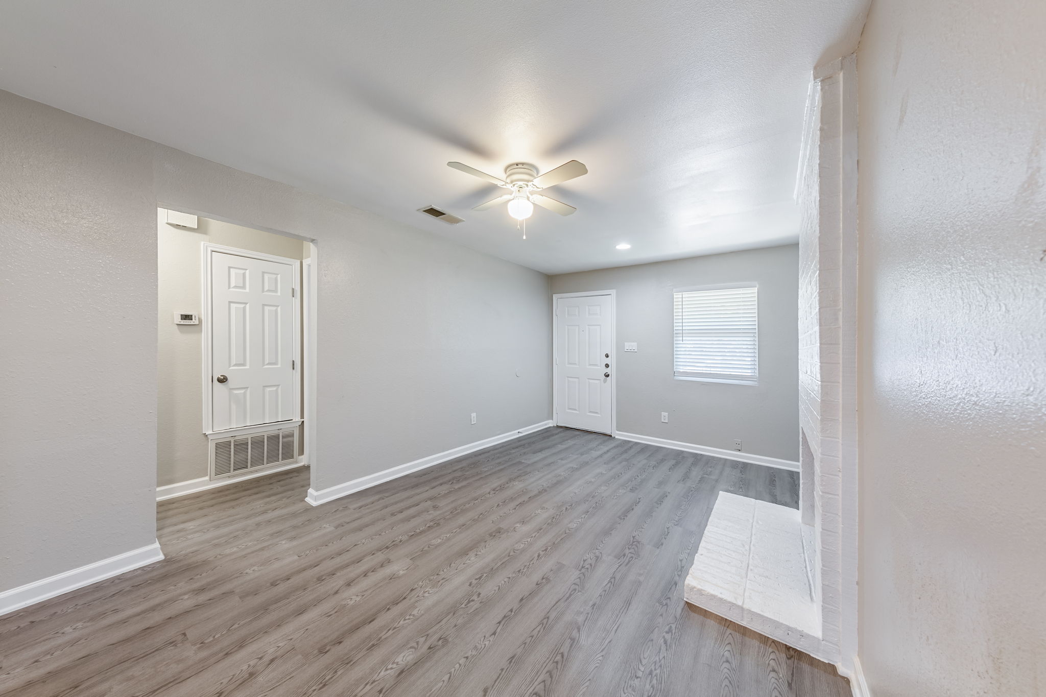 2011 East Stassney Lane, Unit A Austin, TX 78744 - Photo 6 of 23 an empty room with wooden floor and ceiling fan