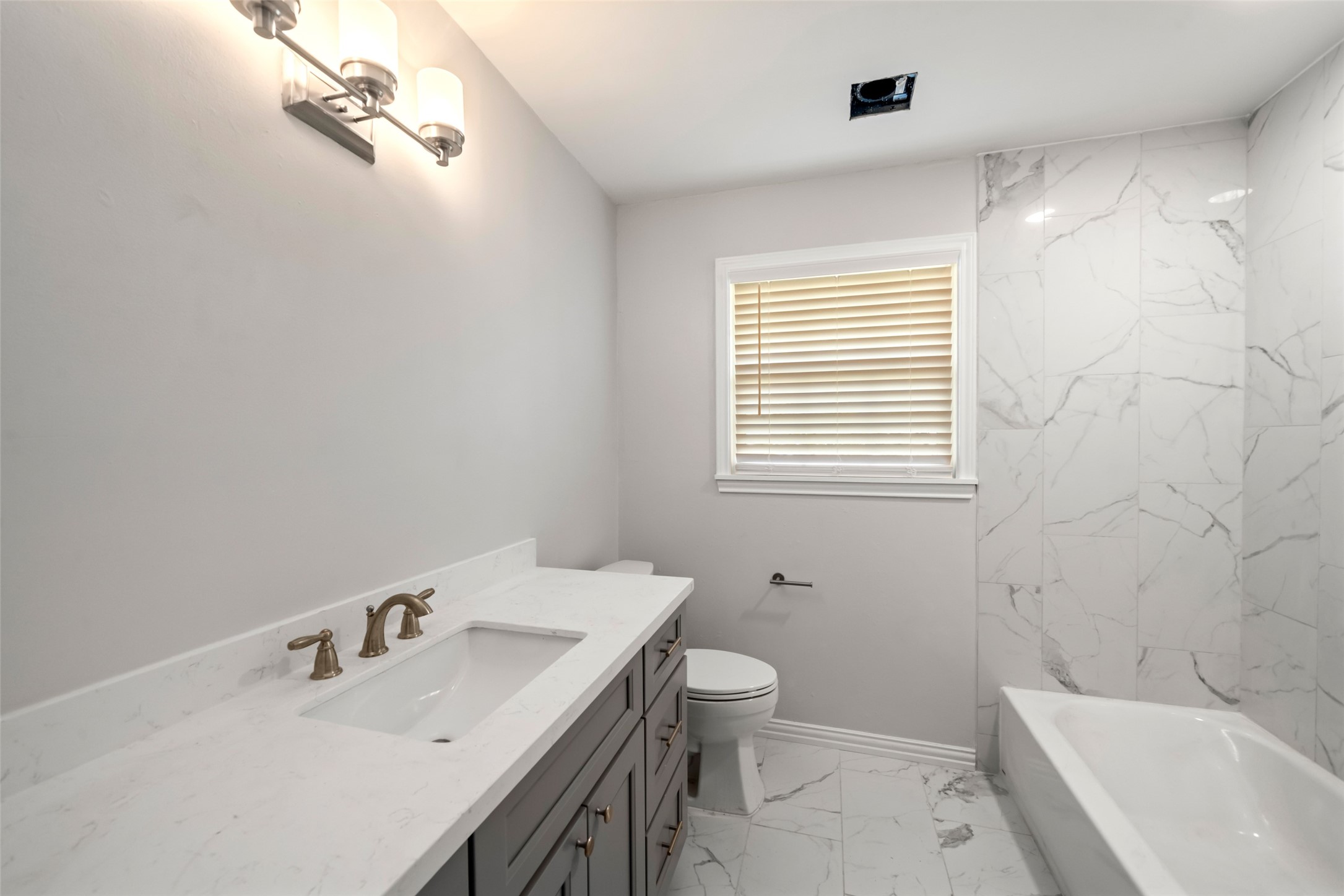 9779 Westview Drive Houston, TX 77055 - Photo 19 of 27 a bathroom with a sink a toilet and a bathtub