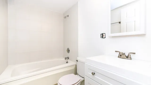a bathroom with a bathtub shower sink and toilet