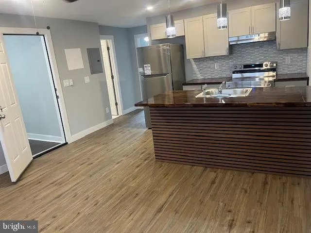 a kitchen with stainless steel appliances granite countertop a refrigerator and a stove