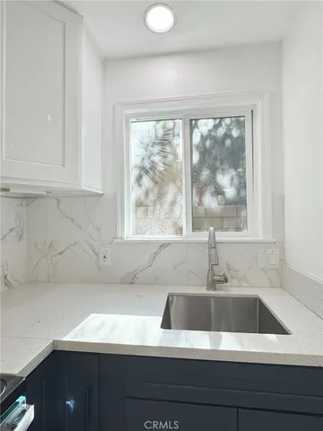 a kitchen with a sink cabinets and a large window